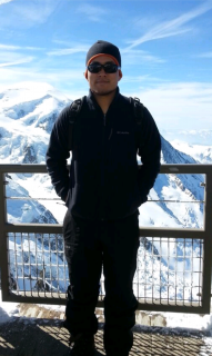 雪山を背景に帽子とサングラスをかけて顔が見えない男性の写真